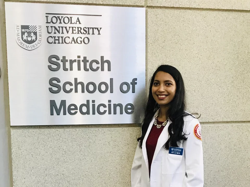 Mahuya Barua, former lab member, stands next to a Stritch School of Medicine sign where she has been admitted 