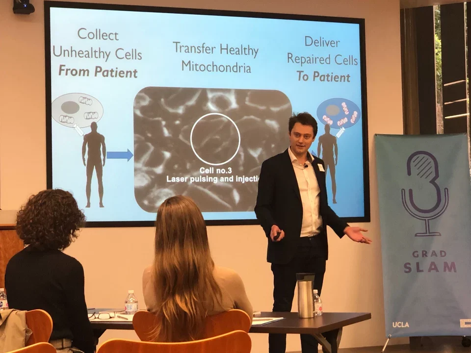 Grad student, Alex Sercel, wears a suit jacket and presents his research for the Grand Slam competition 