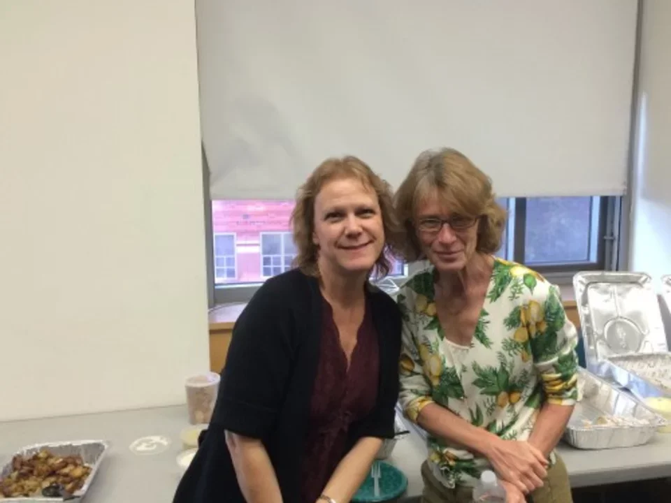 2014/12/4 - two lab members smile together in front of a buffet of food