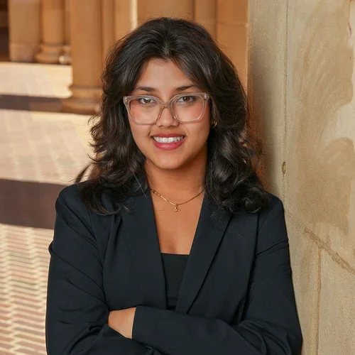 Bibhabari smiles, leaning against a column