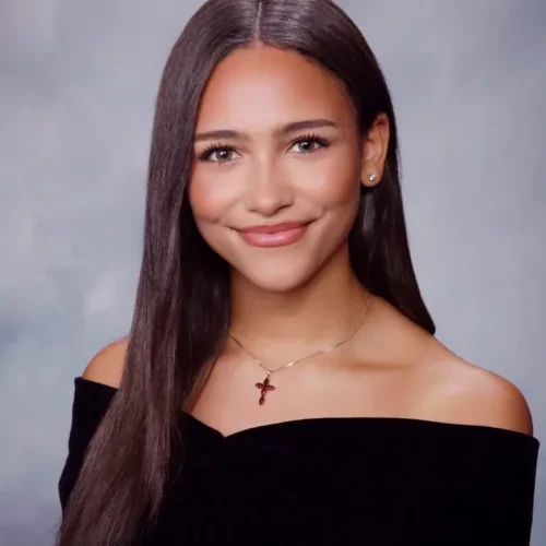Professional-looking portrait of Isabelle Gibson. She's smiling and wearing a formal black shirt.