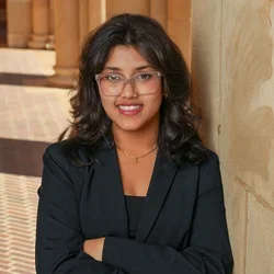 Bibhabari smiles, leaning against a column