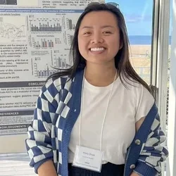 Mary Doan smiling in front of her academic poster